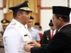 Gubernur Kepulauan Riau, Ansar Ahmad, memasangkan pin kepada Bupati Bintan yang baru Roby Kurniawan